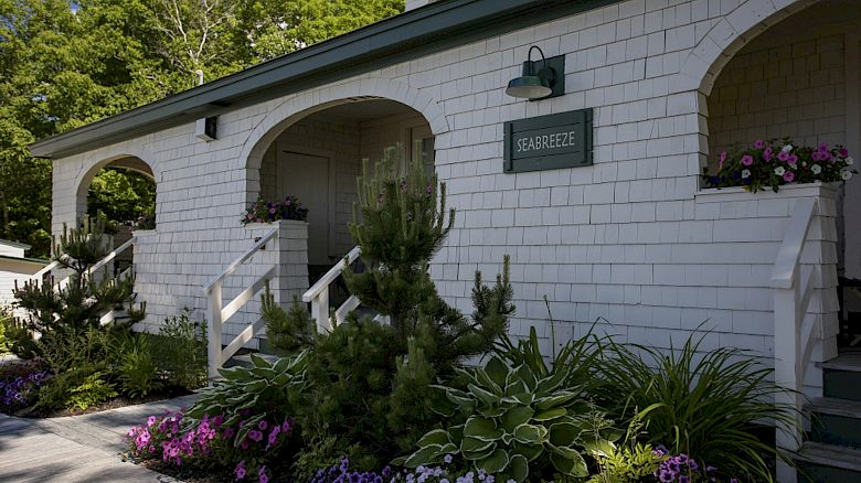 A white house with arched doorways, a green 