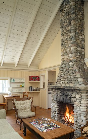 Cozy room with a stone fireplace, wood on the floor, puzzle on the coffee table