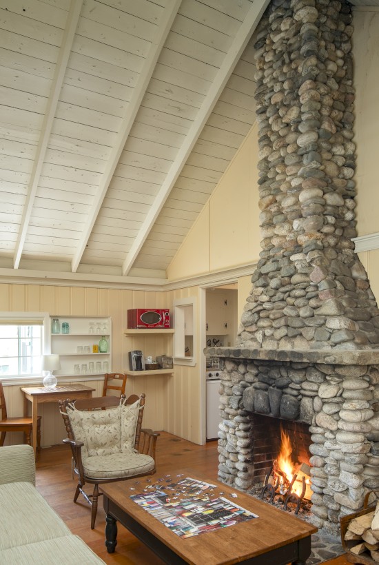 Cozy room with a stone fireplace, wood on the floor, puzzle on the coffee table